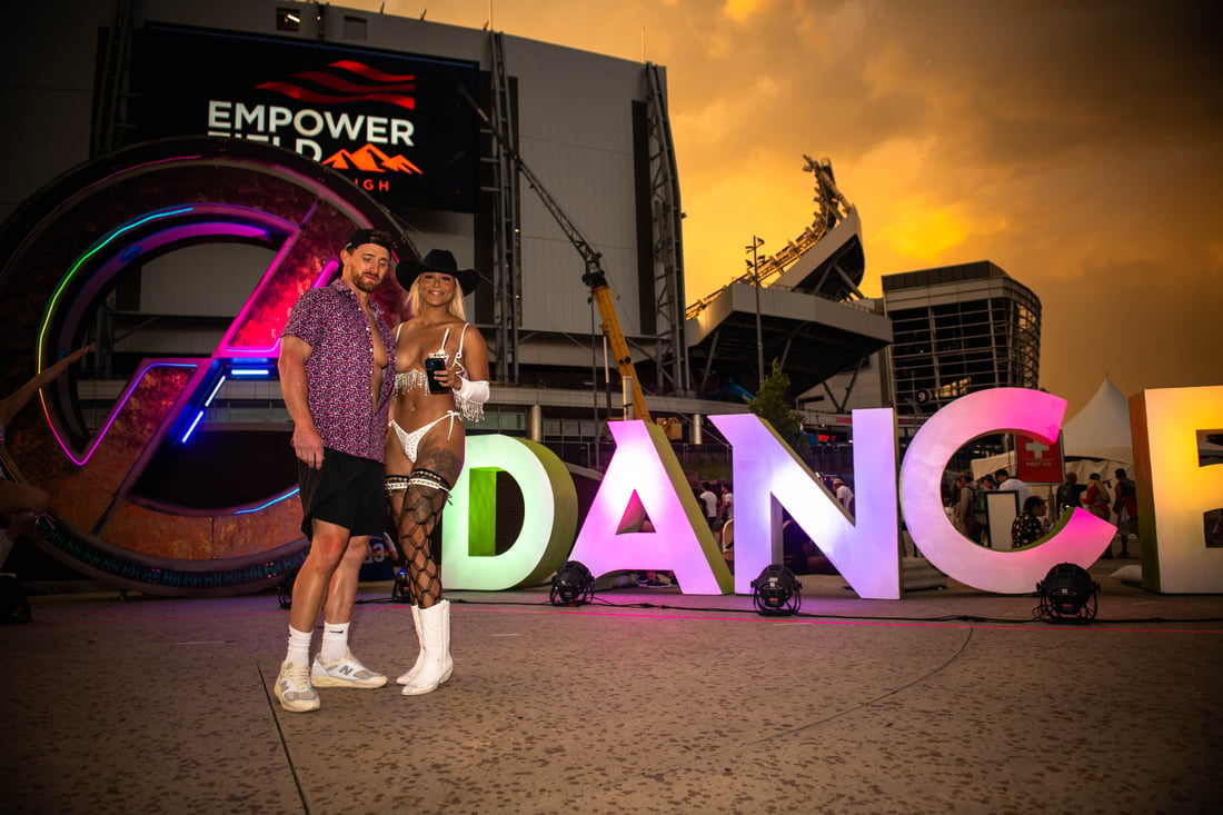 Guests celebrating beside illuminated event signage