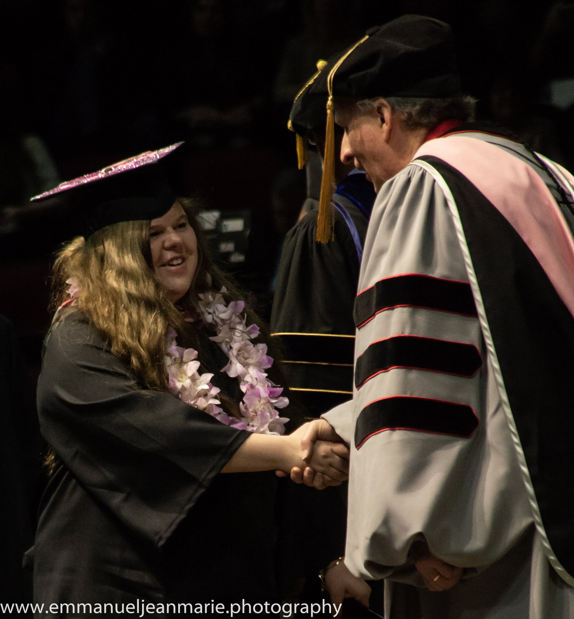 A graduate crossing the stage with a handshake