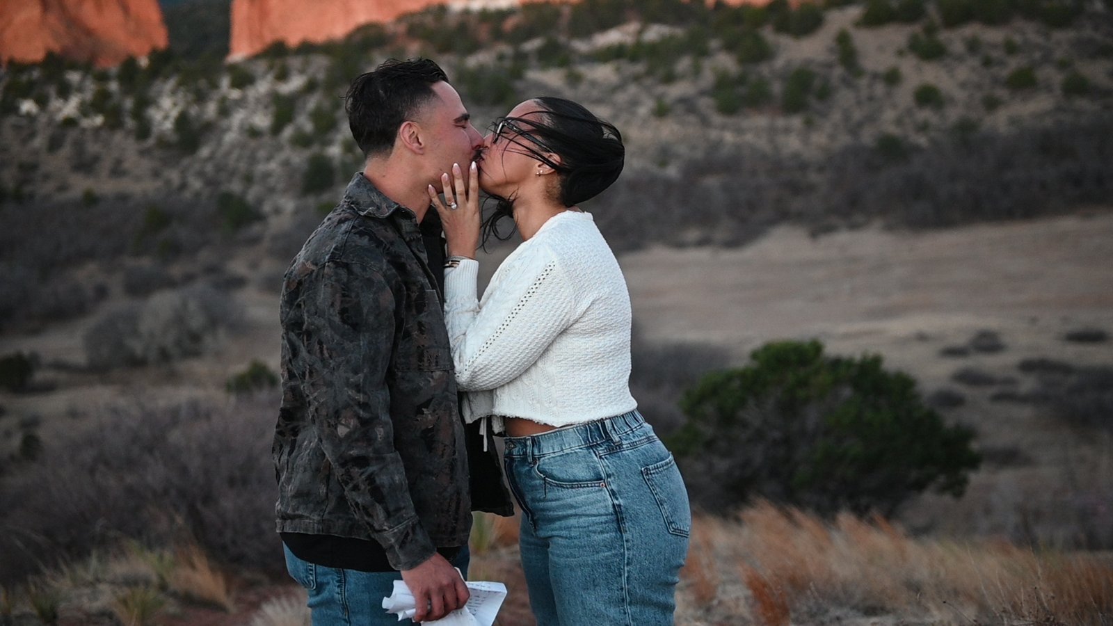 A couple in a golden-hour embrace after a proposal