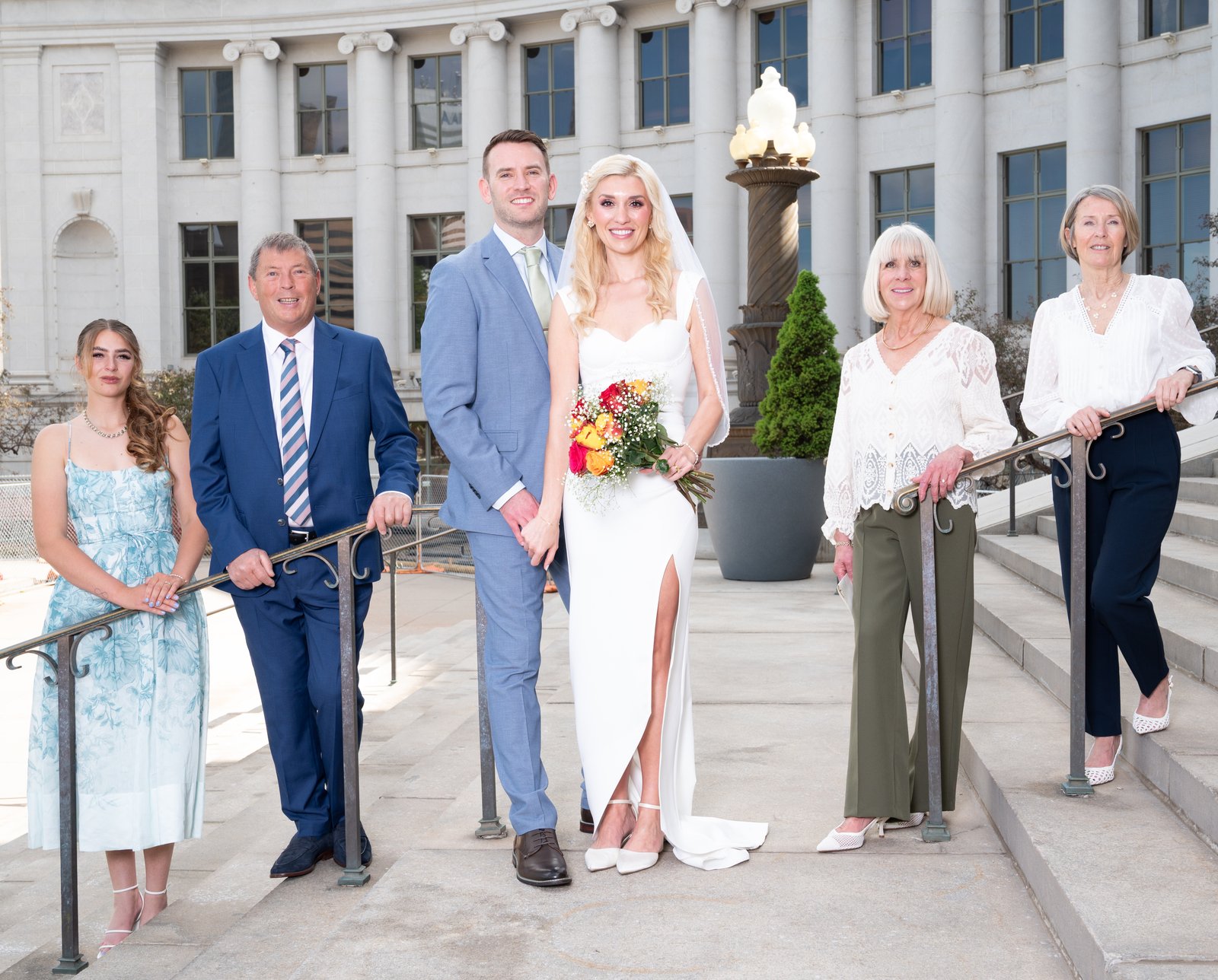 A couple on the grand steps of their wedding day