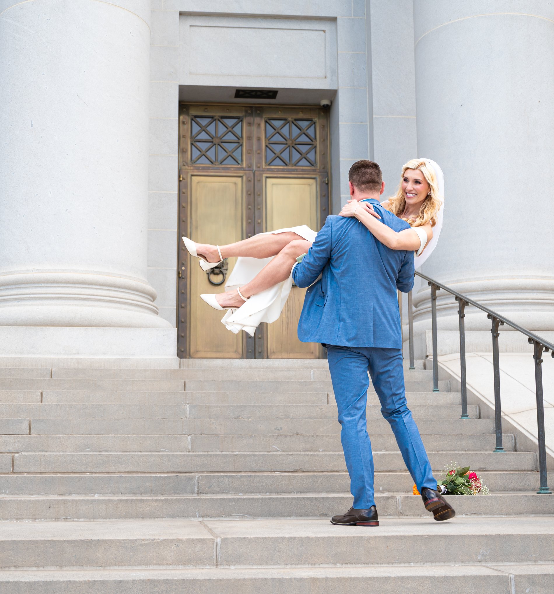 A groom carrying his bride up the capitol steps on their wedding day, Perfectionshoots Colorado event photography