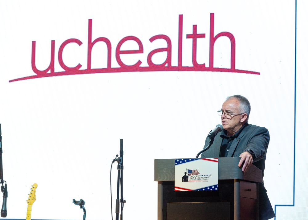 A healthcare leader at the podium, Perfectionshoots Colorado corporate event photography