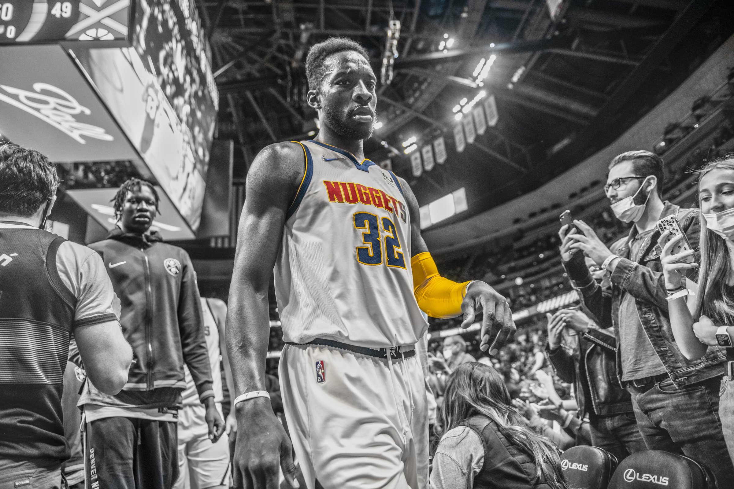 A professional basketball player walks out through the crowd before tip-off, documented by Perfectionshoots