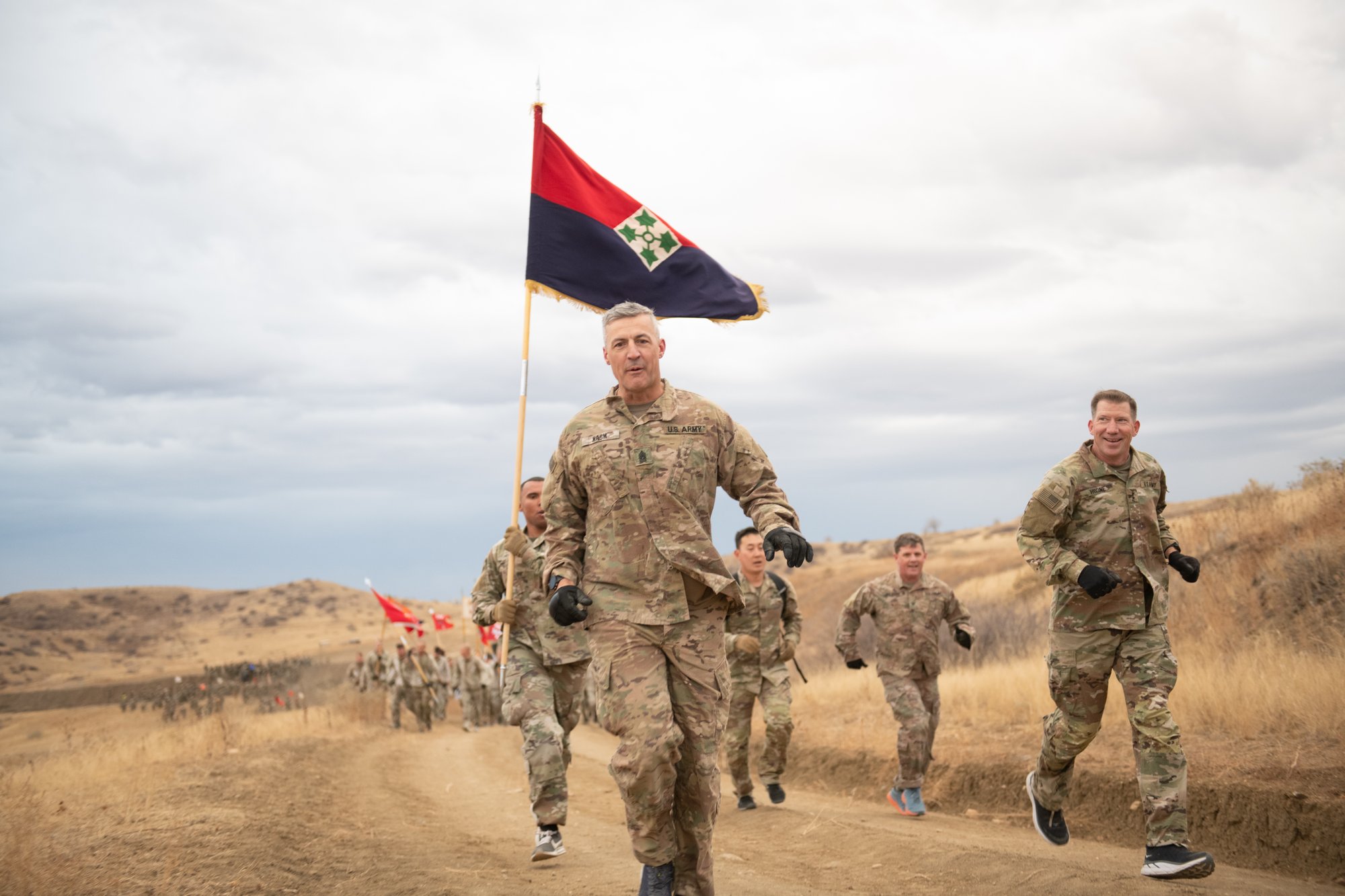 The division commander and division command sergeant major lead their soldiers on a division run beneath the colors, documented by Perfectionshoots