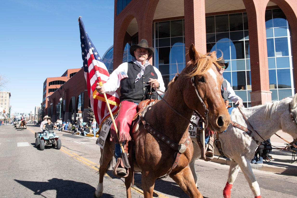 An American flag rides through downtown on horseback, Perfectionshoots military and veteran event photography