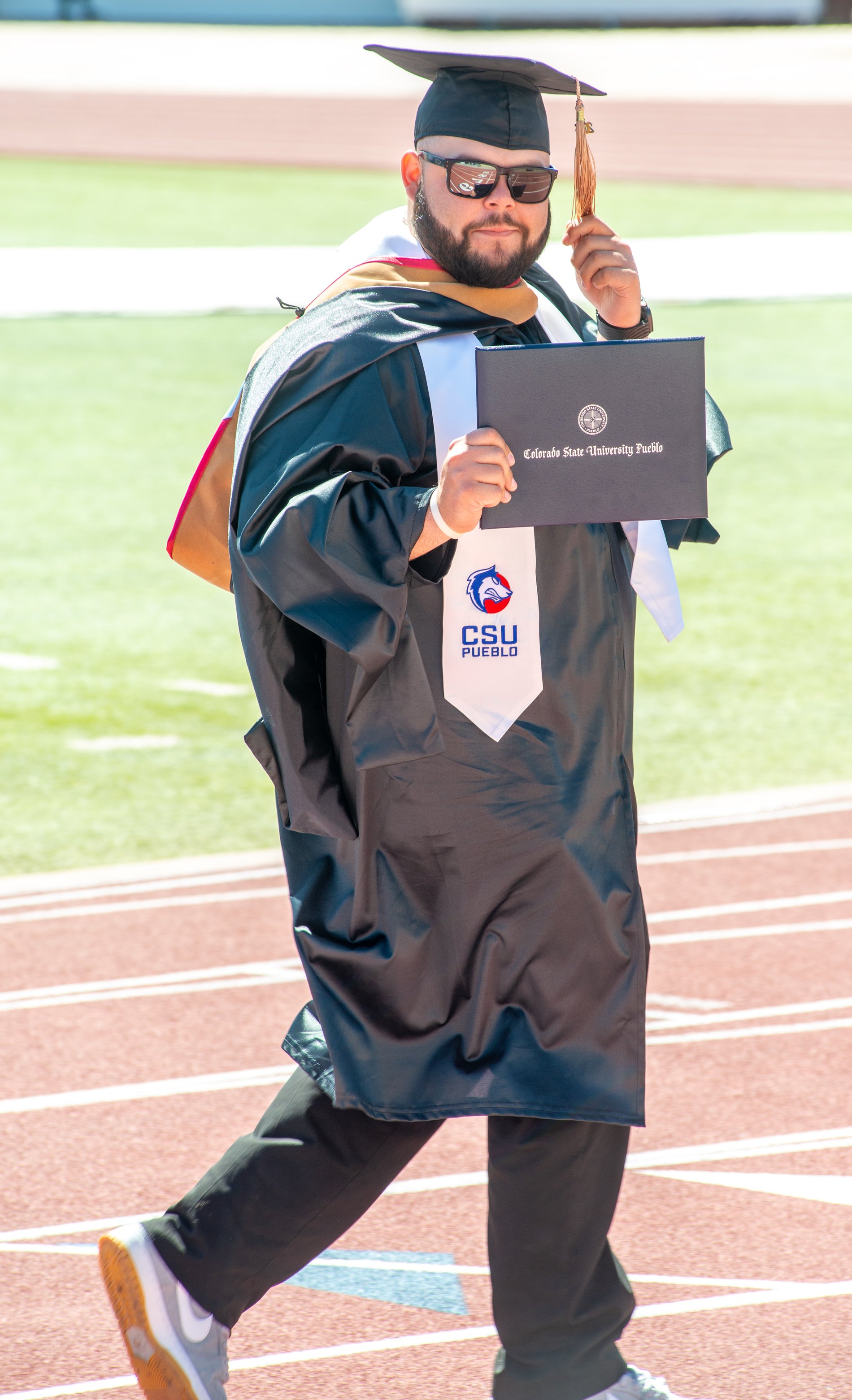 A graduate walks the track with his diploma