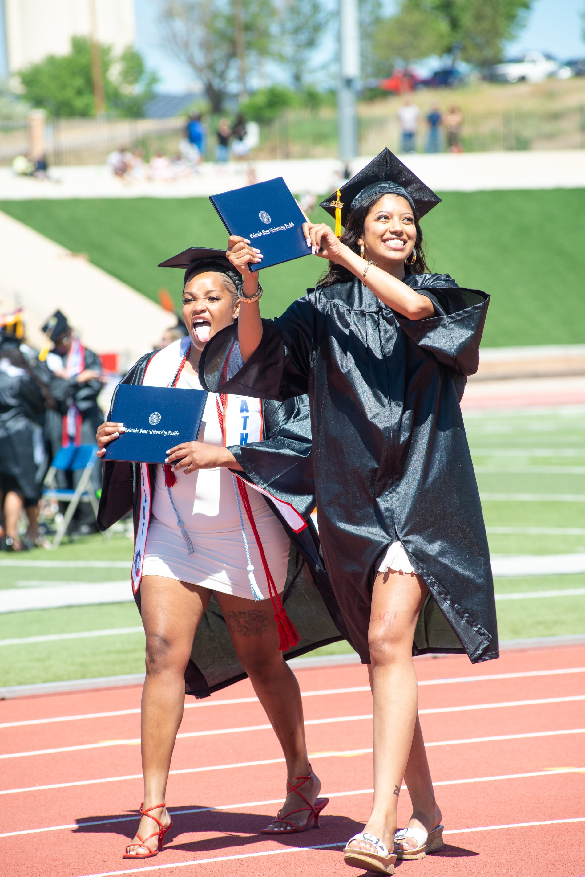Graduates celebrating on the track at commencement