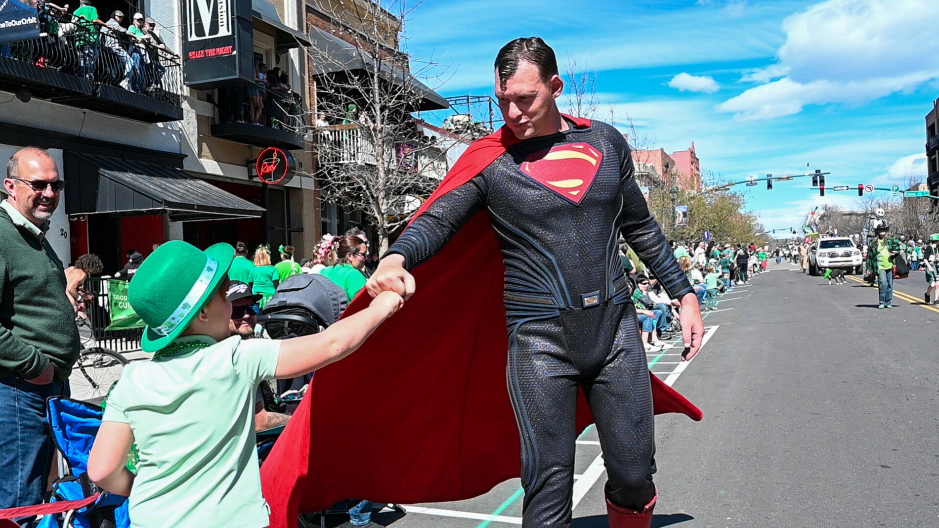 A caped hero greets the crowd at a parade, Perfectionshoots Colorado event photography