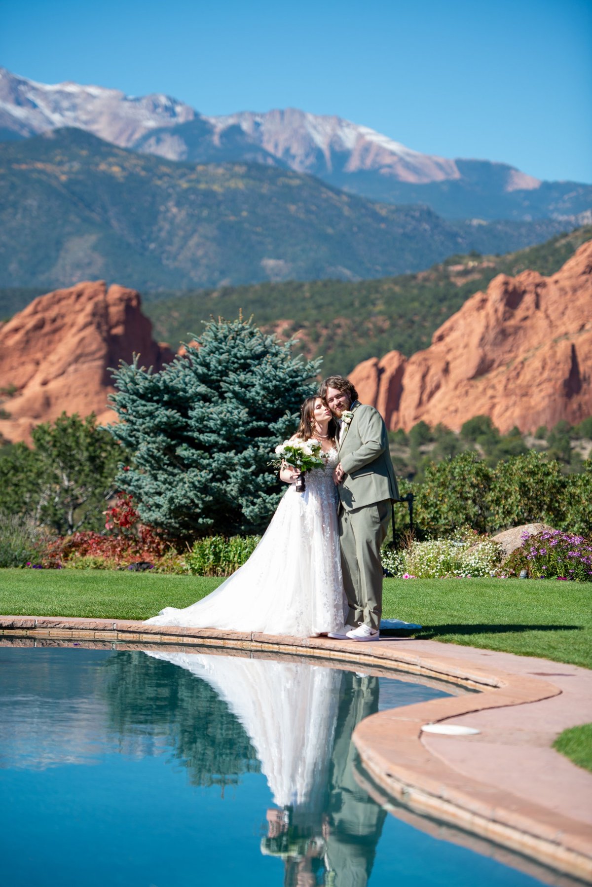 A couple at the Reflection Pool beneath snow-capped Pikes Peak, Garden of the Gods Resort wedding, Perfectionshoots Colorado wedding photography