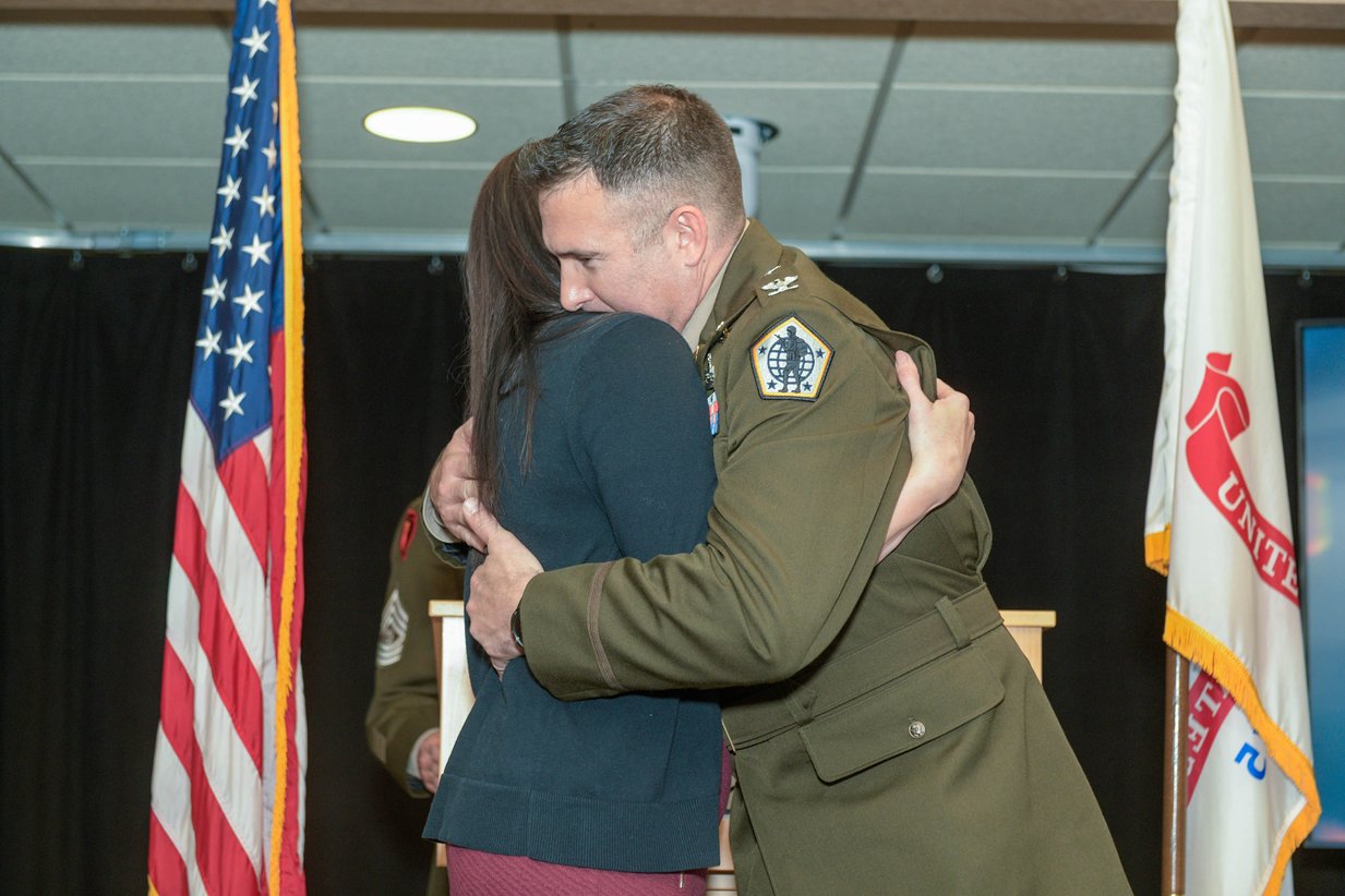 A promotion ceremony embrace beneath the colors, Perfectionshoots military and veteran event photography