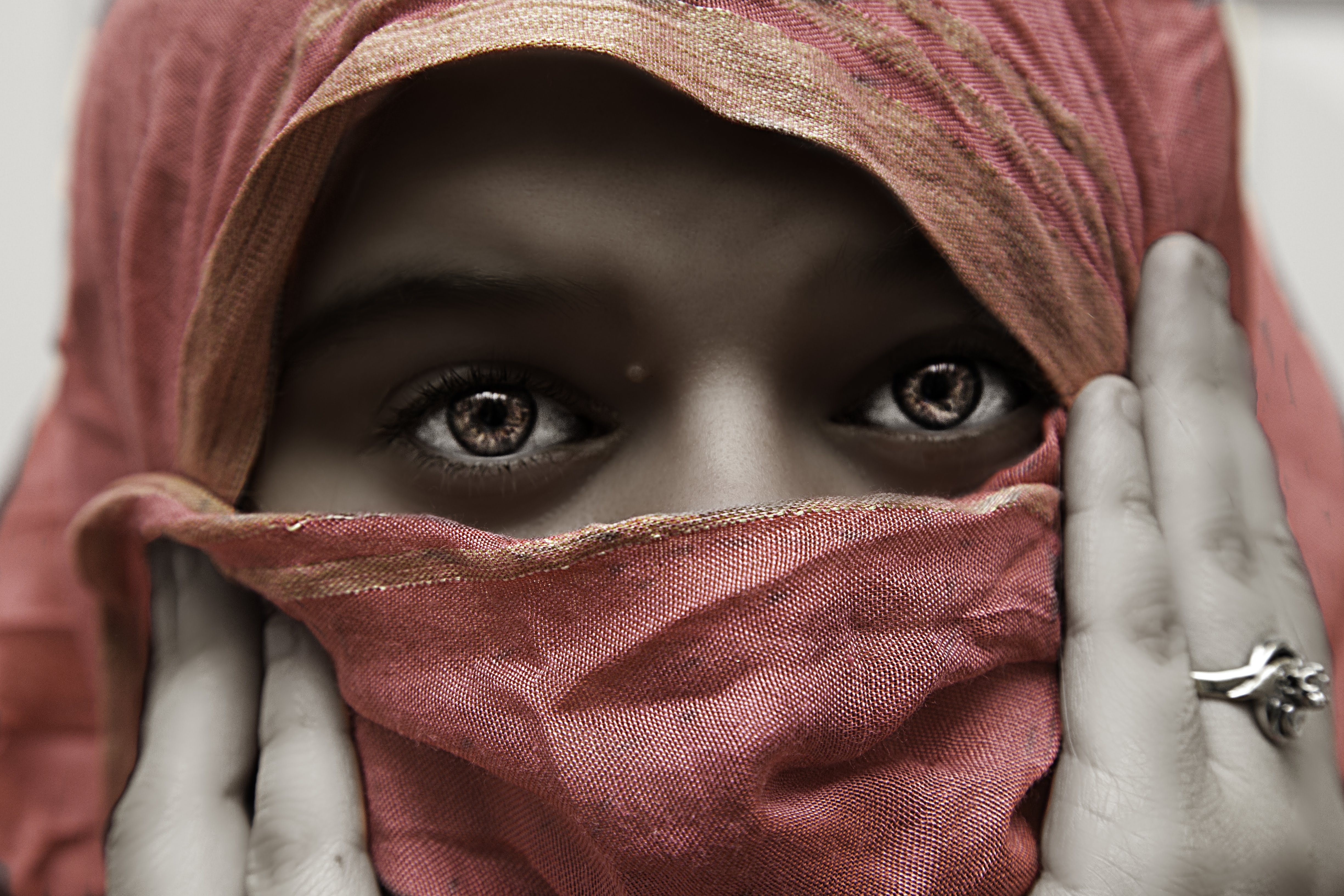 Close-up of Abby-rose J.Marie wearing a red headscarf with intense eyes gazing forward, partially covering her face. Boston MA 2016